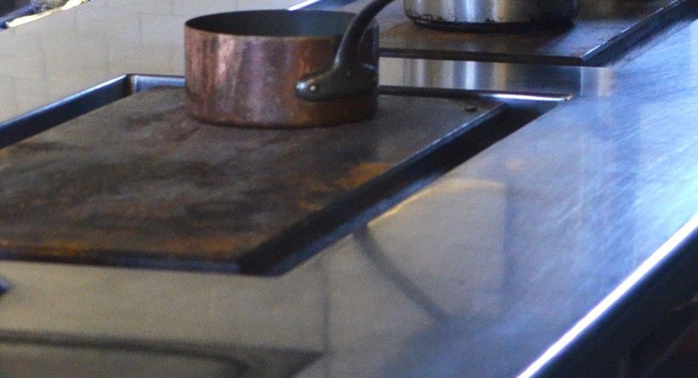 Жарочная плита профессиональной кухни с запекшимся жиром и нагаром